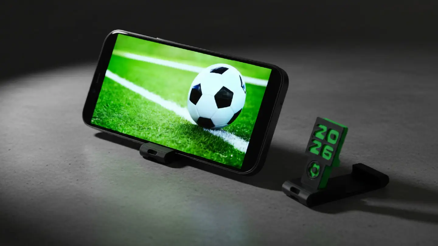 Green KlickStand phone stand holding a phone during a soccer match